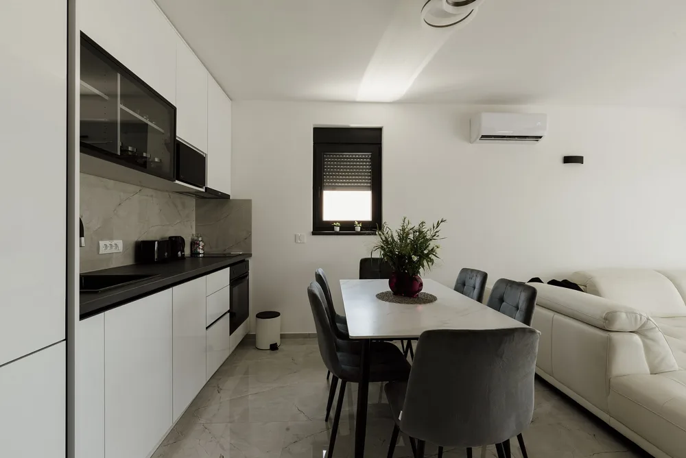 Bright, spotless white kitchen and dining area, freshly cleaned and ready for a new tenant